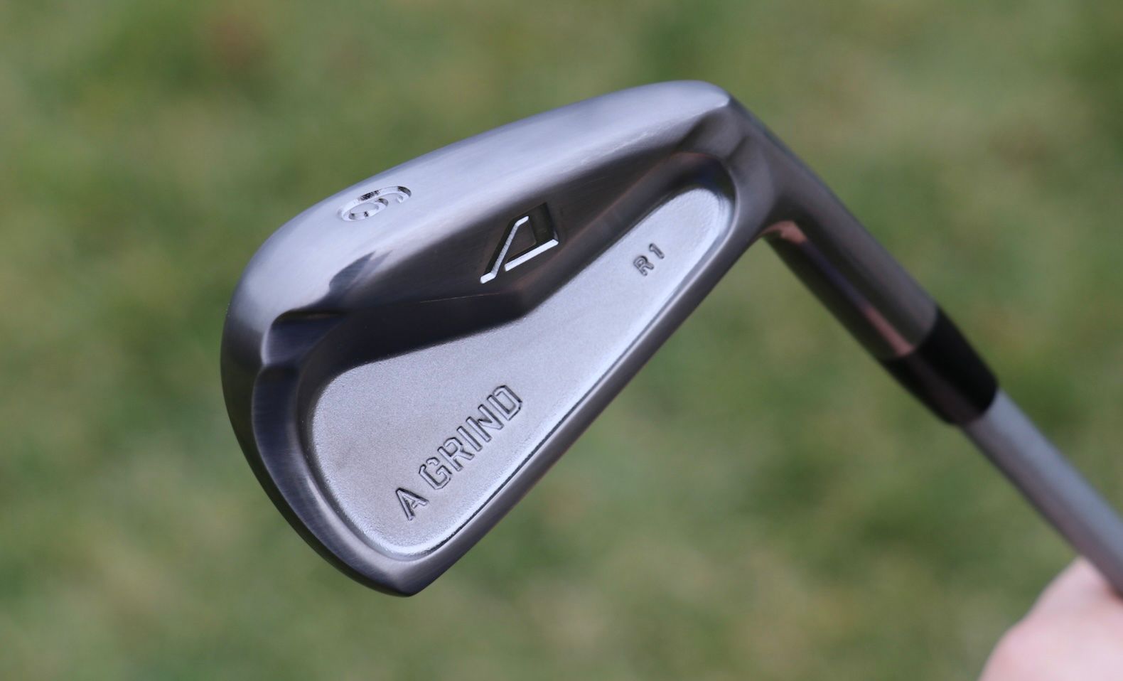 Silver and black Mizuno golf iron club head, with "MIZUNO" clearly visible.
