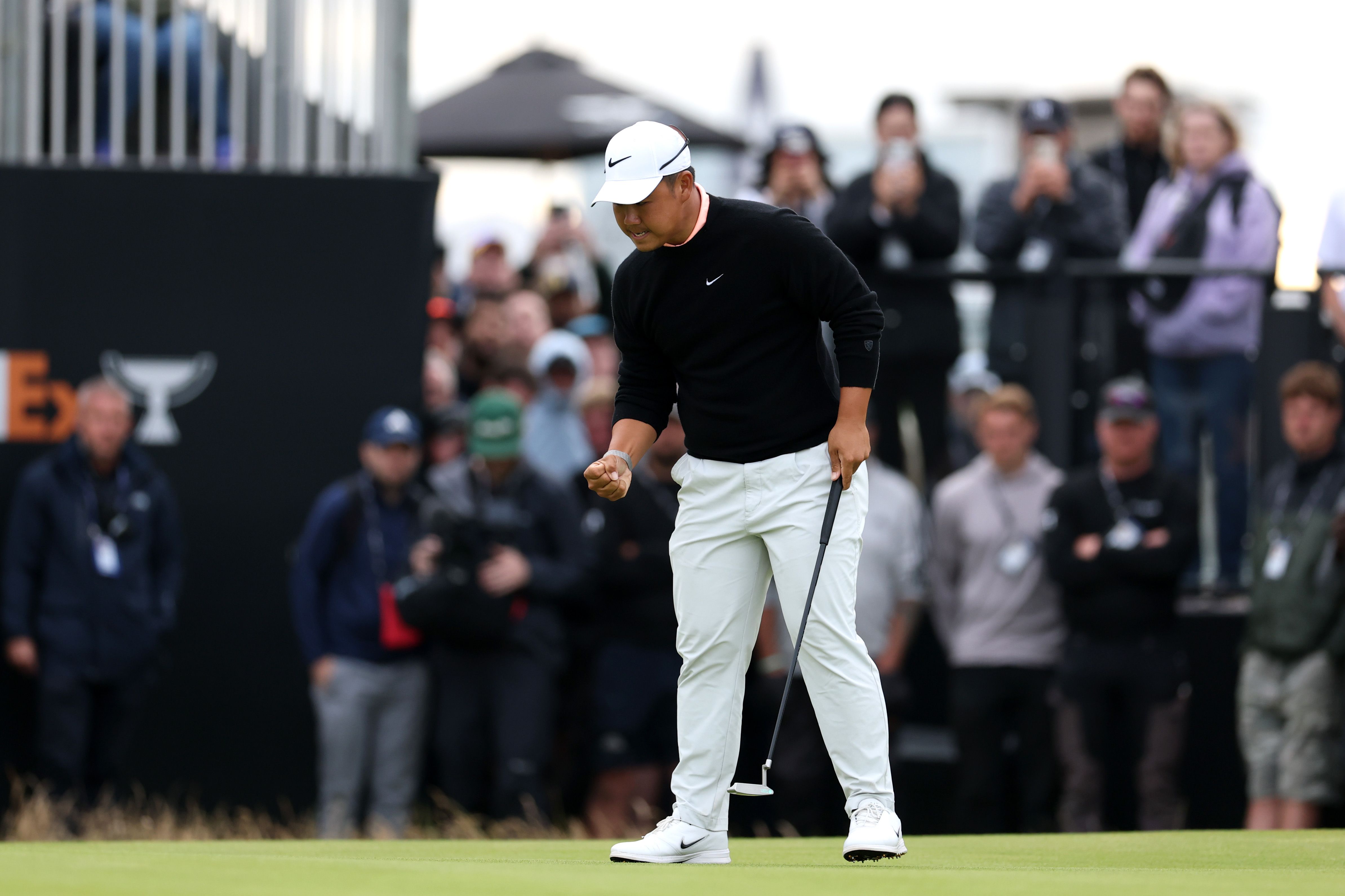 Golfer Brooks Koepka looks down, seemingly frustrated, on the green after a shot.