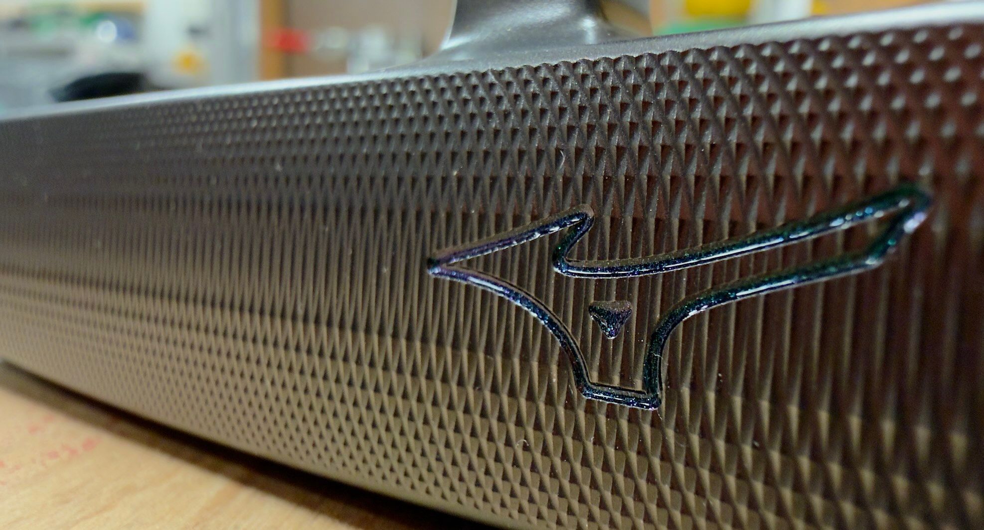 Close-up of a dark, finely textured surface featuring the Mizuno logo.