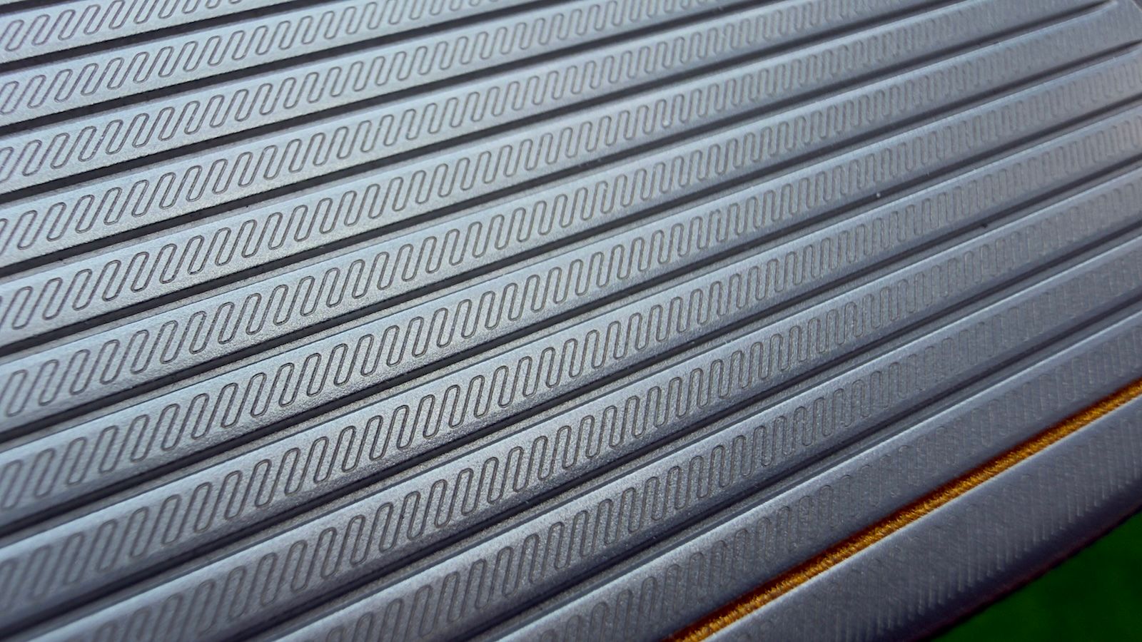 Close-up of gray corrugated metal sheets arranged diagonally, showing textured surfaces.
