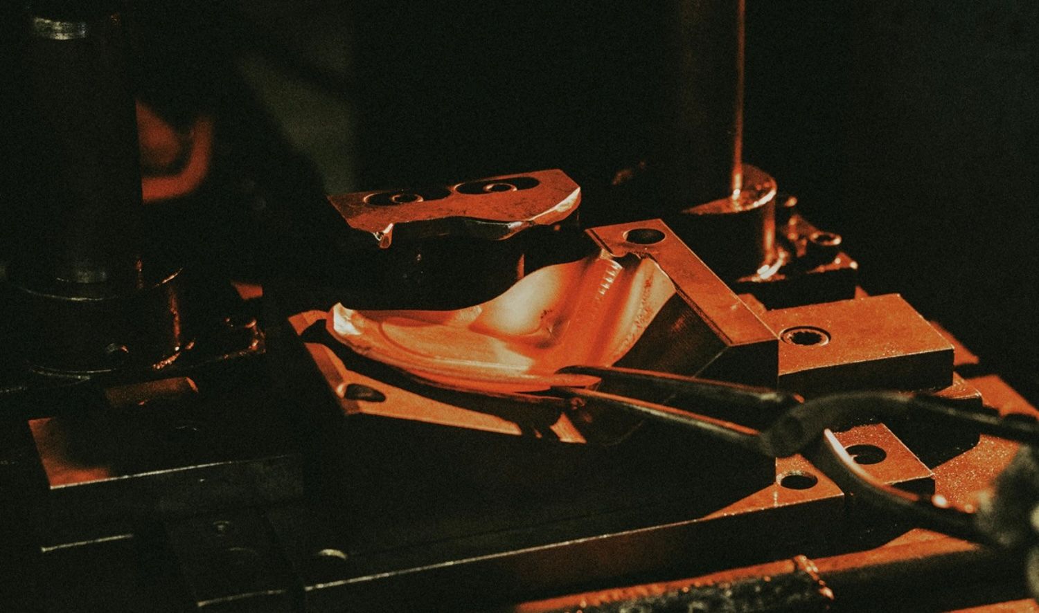 A guitar rests on a stand in a dimly lit room, awaiting its player.